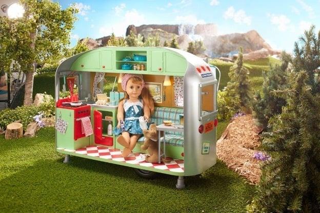 A doll sitting in a toy airstream.