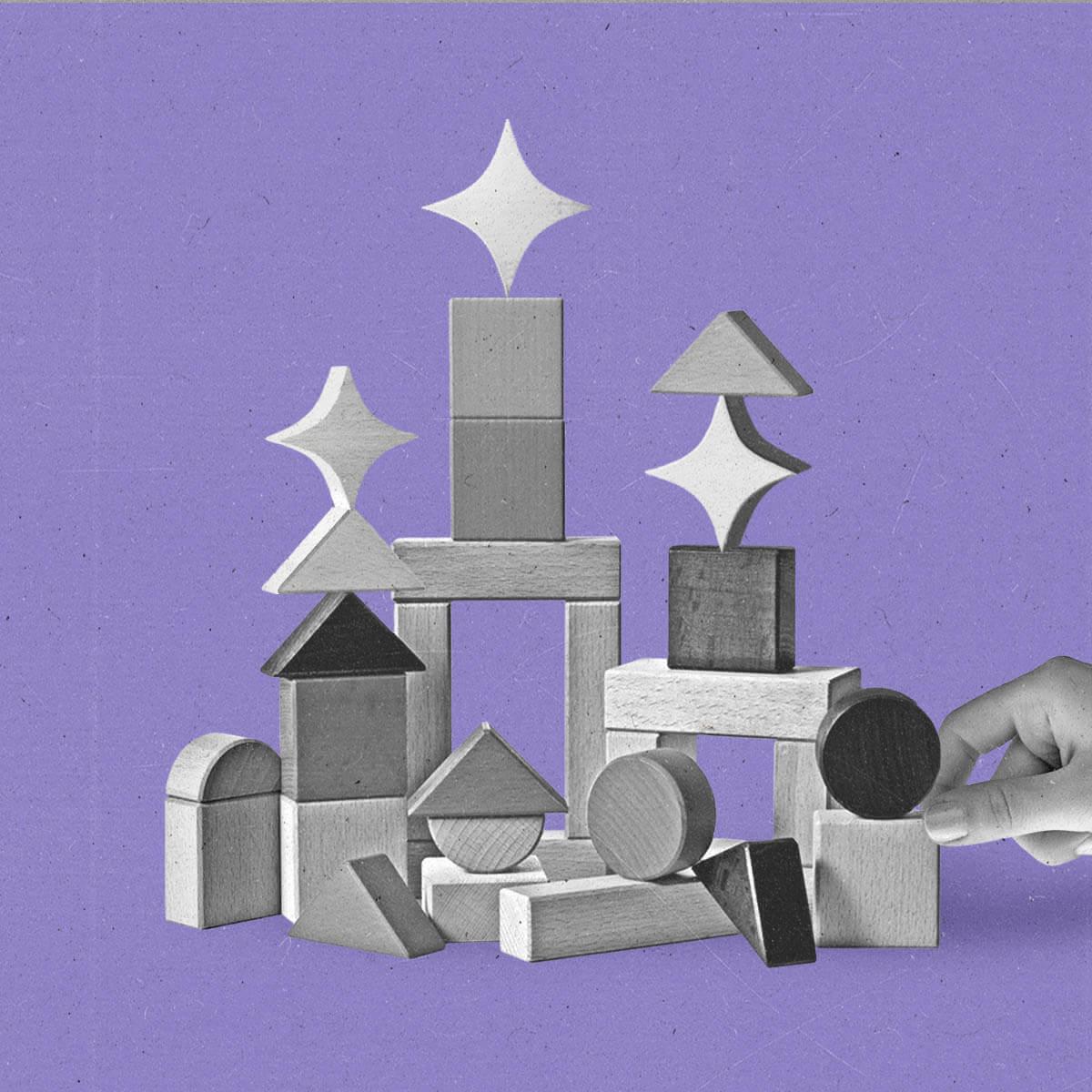 A hand stacks building blocks with sparkles.