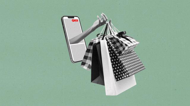 A hand protrudes out of a smart phone with a live recording holding shopping bags.