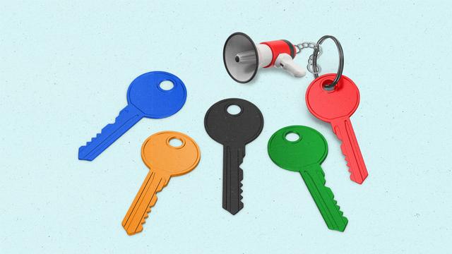 Keys lined up in blue, yellow, black, green, and red with one having a megaphone keychain.