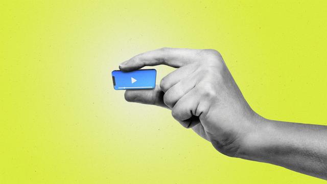 Hand pinching a miniature smartphone that's playing video content.