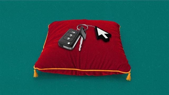 Car keys with a cursor on the keychain, resting on a red velvet pillow.
